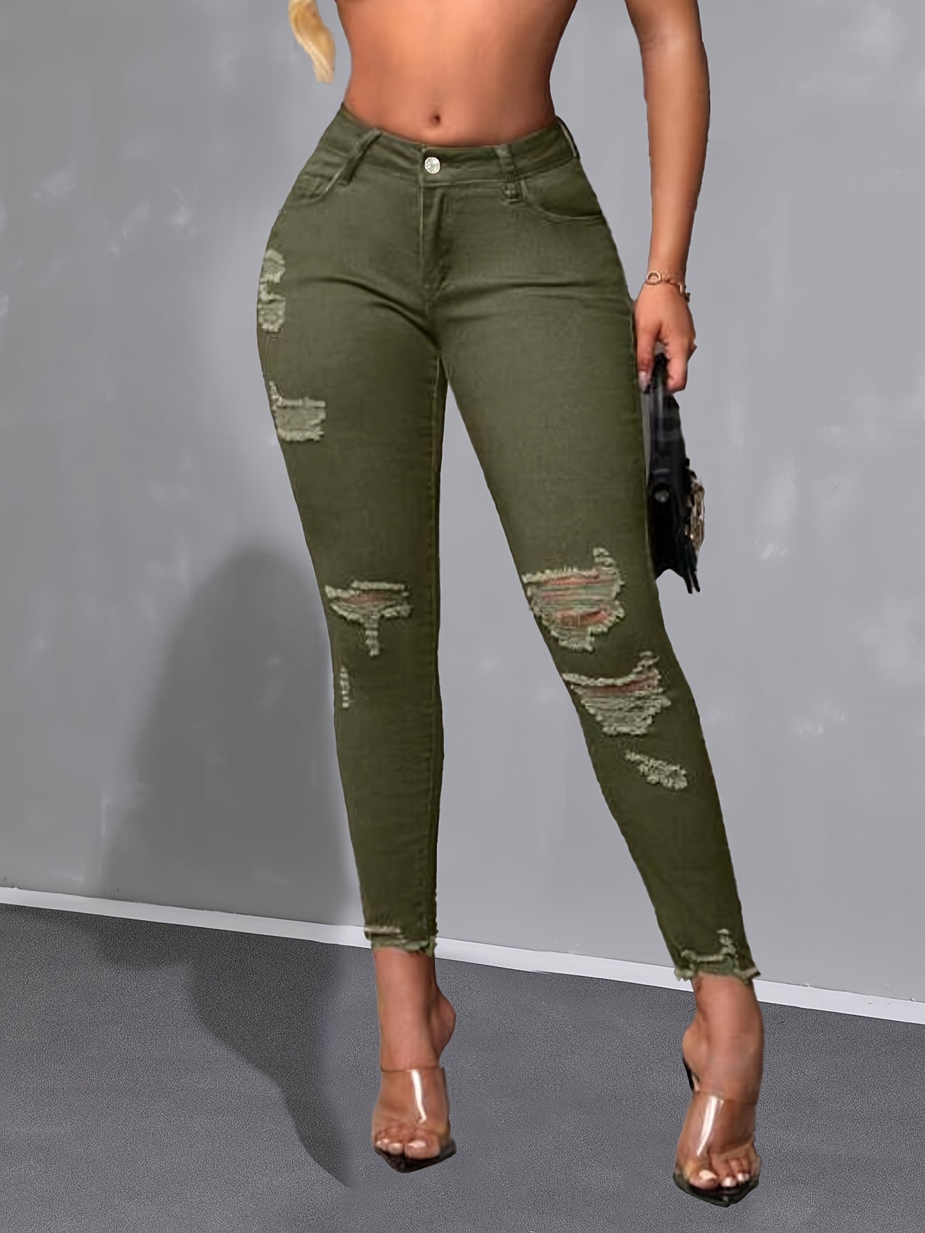 Calça skinny verde militar de cintura alta, moderna e versátil, com detalhes desgastados nas bordas.