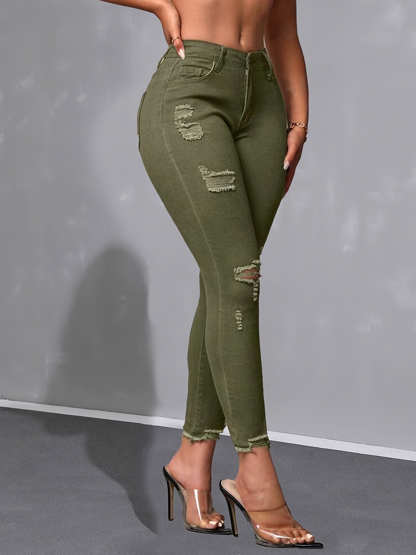 Calça skinny verde militar de cintura alta, moderna e versátil, com detalhes desgastados nas bordas.