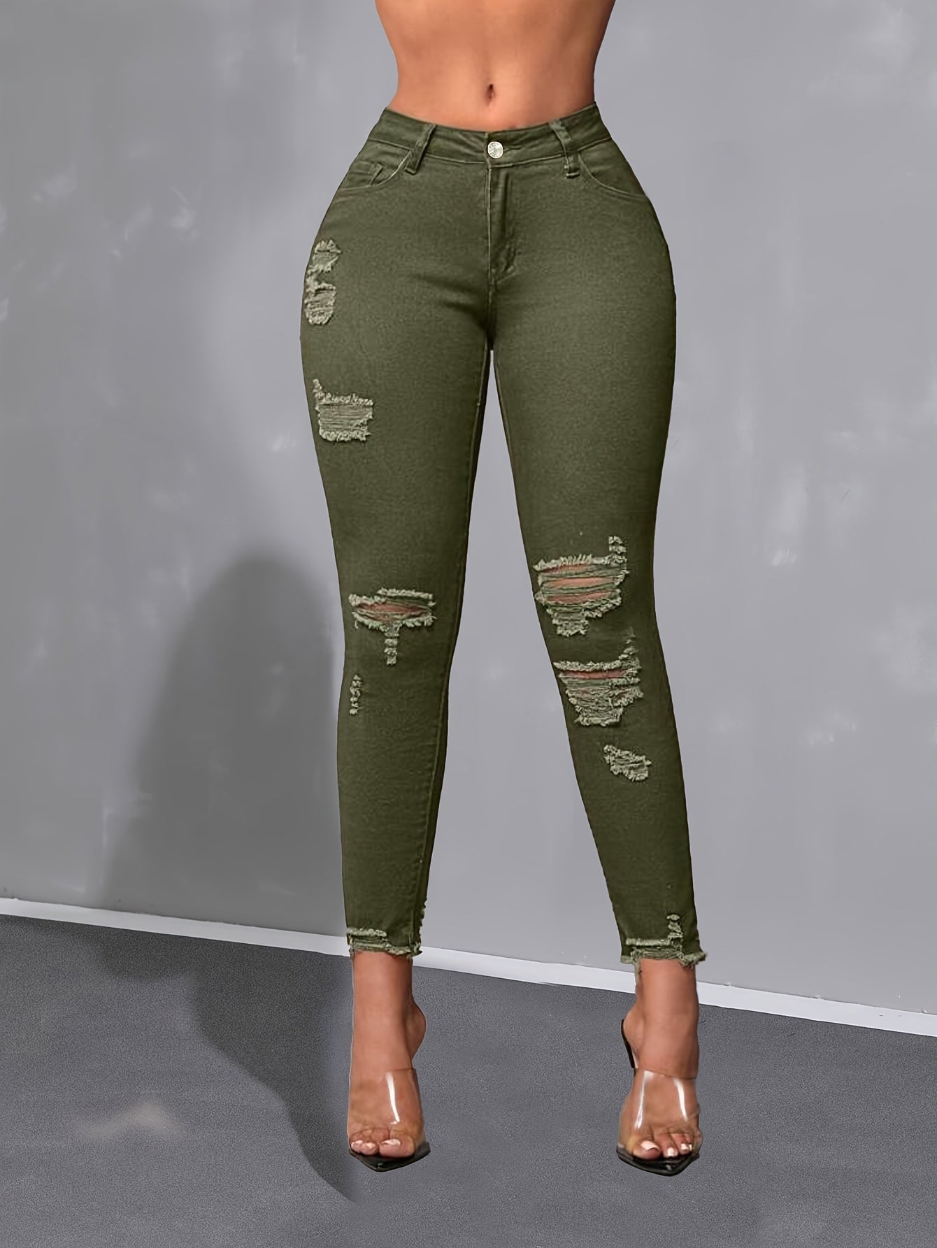 Calça skinny verde militar de cintura alta, moderna e versátil, com detalhes desgastados nas bordas.